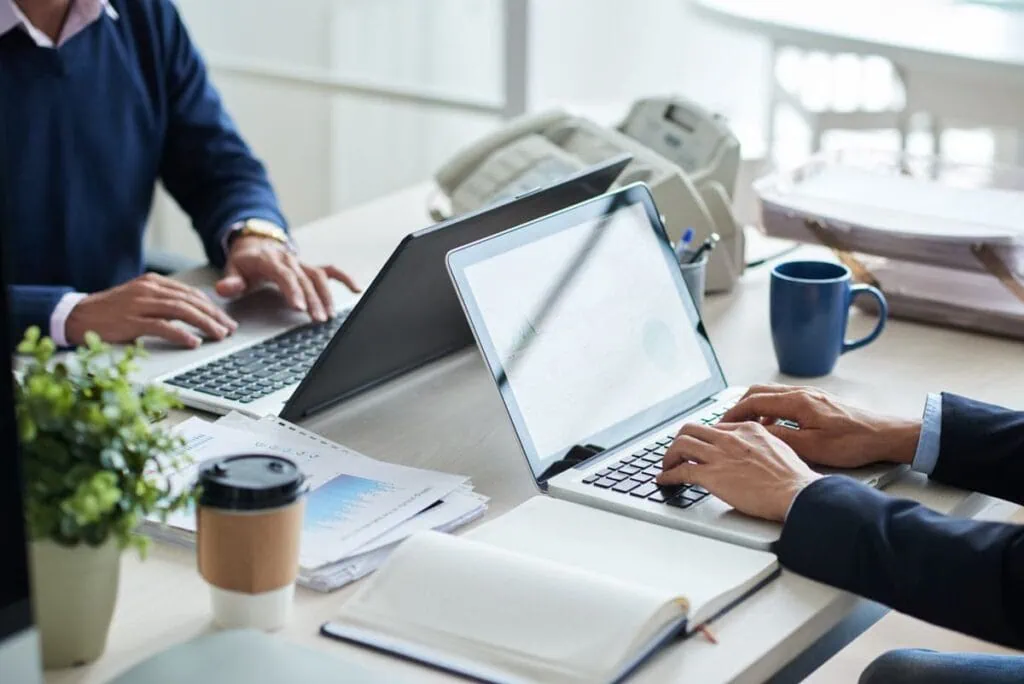 Personen arbeiten an Laptops im Büro